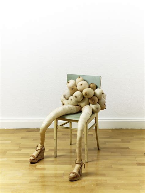 A Woman Sitting In A Chair Made Out Of Vegetables On Her Knees And Legs With One Leg Up