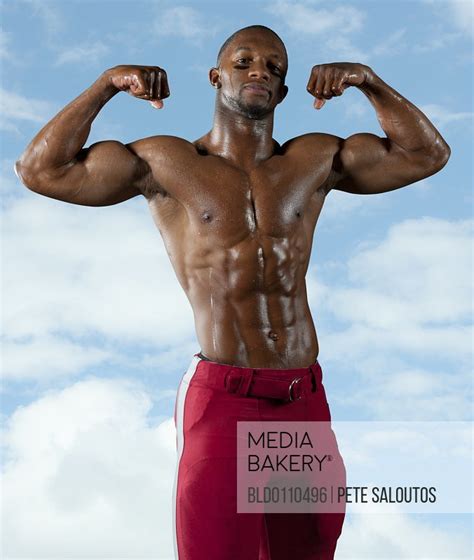 Mediabakery Photo By Blend Images Black Football Player Flexing Muscles