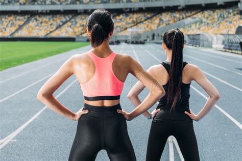 Young Women In Sportswear Exercising On Running Track Stadium Stock