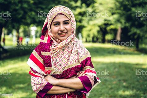 Portrait Of Happy Arabic Muslim Woman With Hijab Dress Smiling And Look At Camera In Summer Park