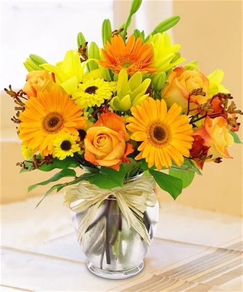 Brightly Colored Yellow And Orange Flowers Designed In A Glass Vase