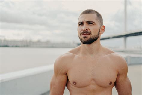 Horizontal Shot Of Muscular Man With Naked Torso Thick Beard Looks Somewhere Into Distance