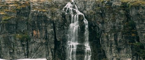 Download Wallpaper 2560x1080 Waterfall Rocks Sea Cliff Stones