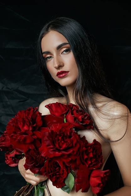 Premium Photo Sexy Brunette With A Bouquet Of Red Roses On The Floor