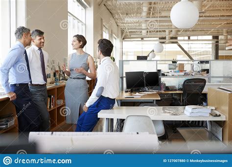 Female Manager In Discussion With Colleagues At Work Stock Photo