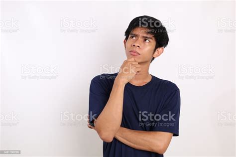 Asian Young Man Standing While Thinking Or Imagining Something Isolated