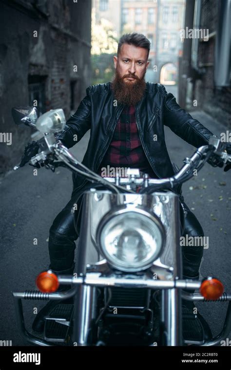 Bearded Biker In Leather Jacket Sitting On Classical Chopper Front