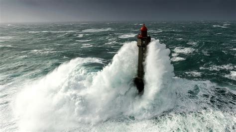 Lighthouse In Rough Sea By Mathieu Rivrin