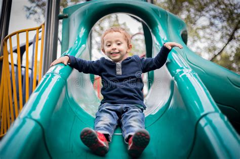 Happy Little Boy On The Playground Slide Stock Photo Image Of