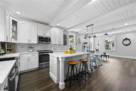 A tall, shiplap covered ceiling and large wood beams lend a grand, breathtaking effect to this simple kitchen design. Shiplap Kitchens (Design Ideas) - Designing Idea
