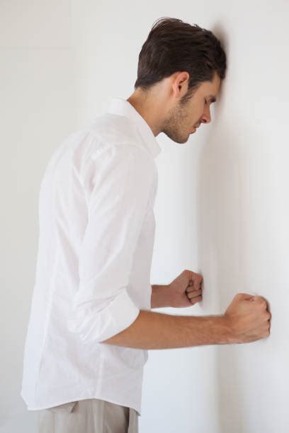 Side View Of A Young Business Man Leaning On Wall Stock Photos