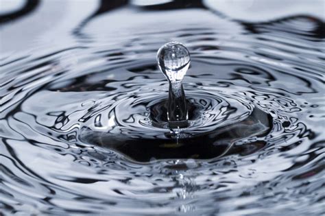 Premium Photo Close View Of A Droplet Of Water Hitting A Surface Of