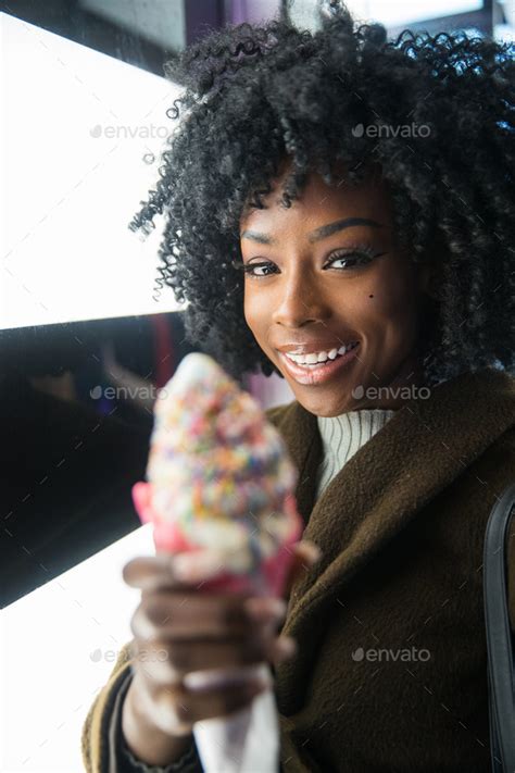 Pretty African American Woman With Black Curly Hair Eating Ice Cream