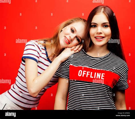 two best friends teenage girls together having fun posing emotional on red background besties