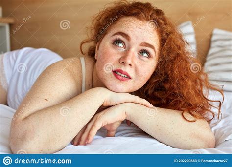 Dream Jolie Femme Avec Des Regards Rouges Naturels De Cheveux Se Trouvant Sur Le Lit Image Stock