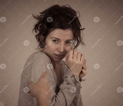 Portrait Of Scared And Intimidated Woman Studio Shot In Moody Light