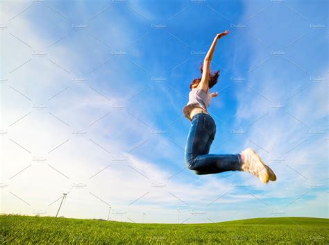 Woman Jumping For Joy On The Field People Images Creative Market