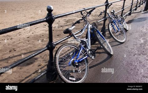 Two Bicycles Locked To Beach Promenade Metal Railings Stock Photo Alamy