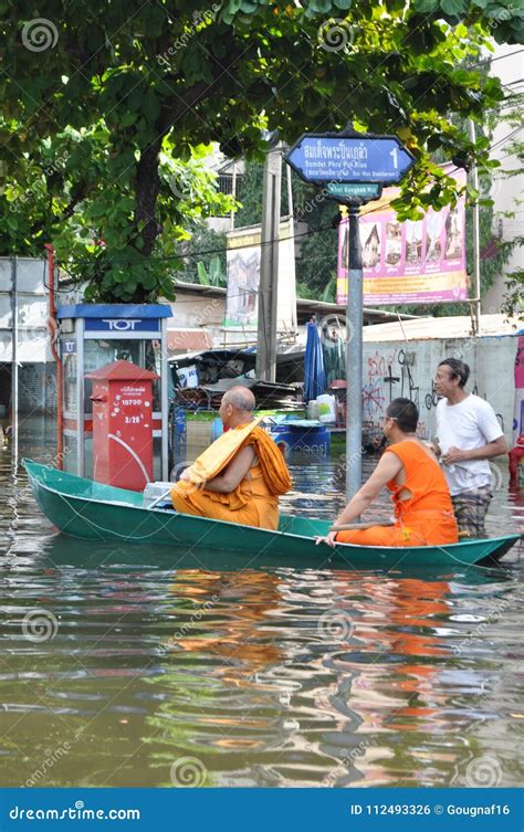 Buddhist Monks Are Rowing Their Boat In A Flooded Street Of Bangkok