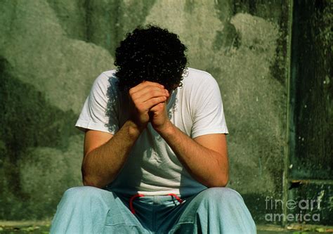 Depressed Teenage Boy Sits By A Wall Photograph By John Greimscience