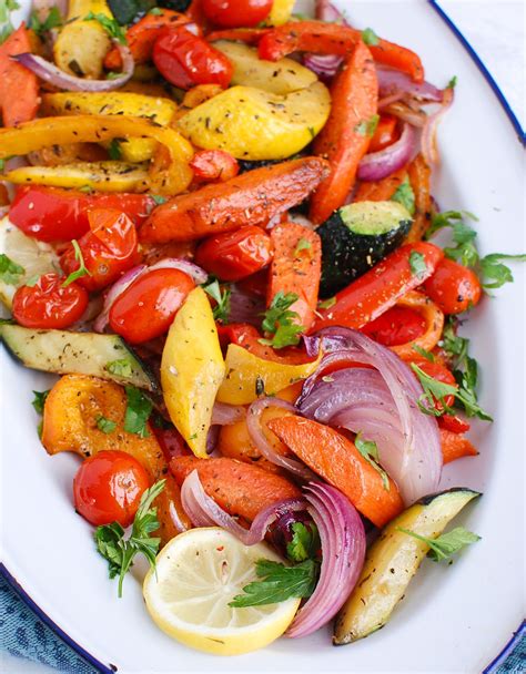 A White Plate Topped With Lots Of Different Types Of Veggies And Lemon