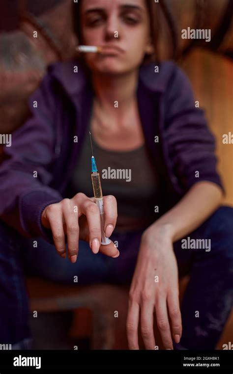 Drug Addict Female Person With Cigarette Holds Syringe In High Shebang