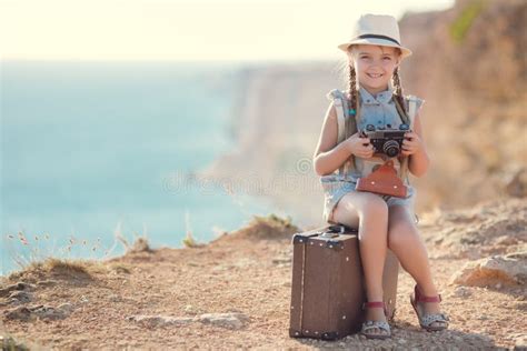 Ein Kleines Mädchen Mit Einer Alten Kamera Auf Einer Landstraße Die Auf Einem Koffer Sitzt