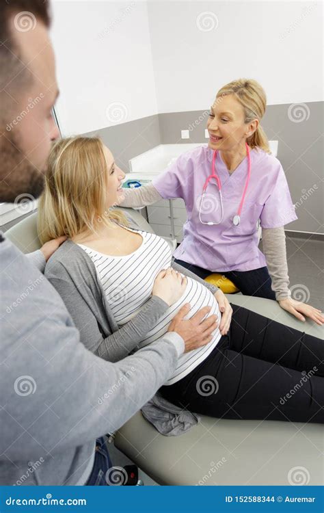 Mujer Embarazada Sonriente Hermosa Con El Doctor Y El Marido Foto De