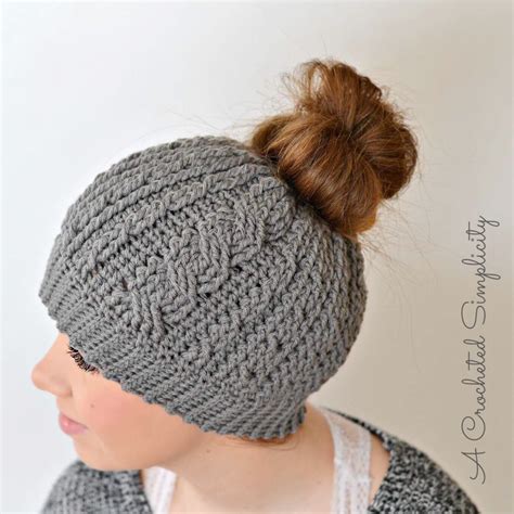 Great for any advanced beginner knitters! Cabled Messy Bun Hat | AllFreeCrochet.com