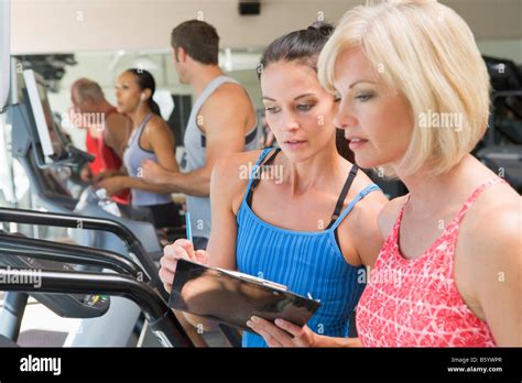 Personal Trainer Instructing Woman On Treadmill Stock Photo Alamy