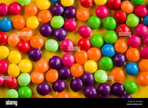 Skittles Candy On The Yellow Table Colorful Sweet Candy Background