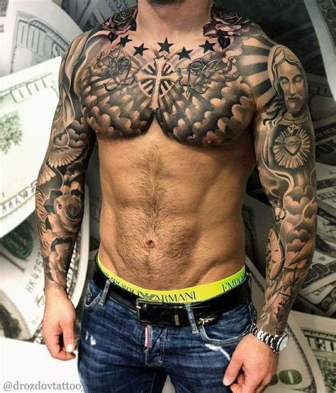 A Man With Tattoos On His Chest Standing In Front Of Stacks Of Money