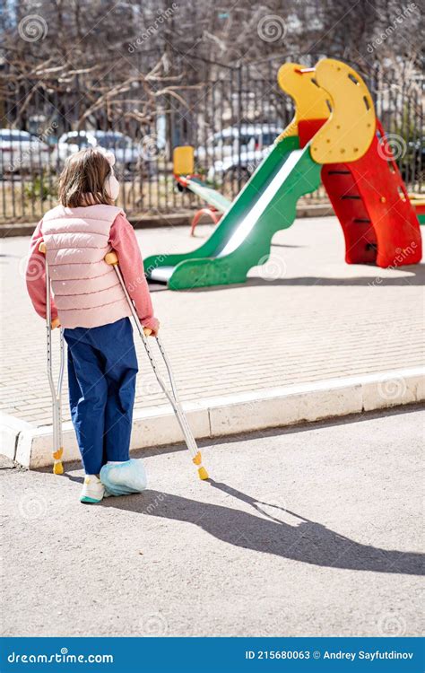 Teen Girl With A Broken Leg On Crutches In The Playground Stock Image