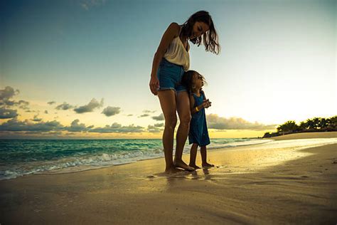 Madre Con Dos Hijos Caminando En La Playa Al Atardecer Banco De Fotos