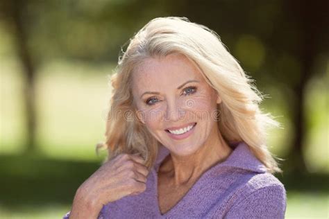 Closeup Of A Senior Woman Smiling At The Camera At The Park Stock Photo