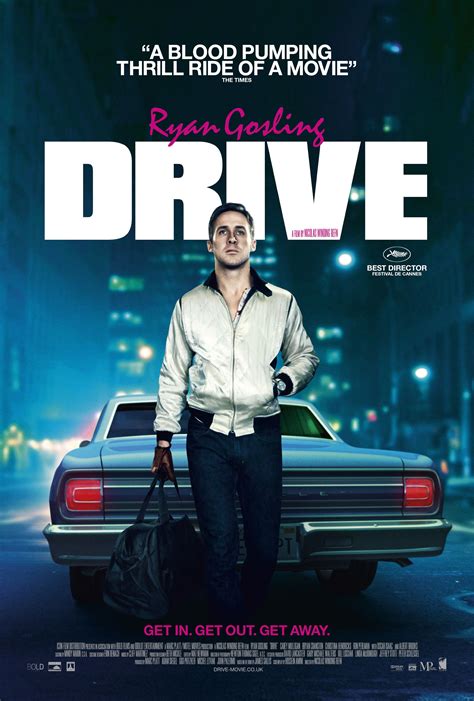 A Man Standing Next To A Car In Front Of A Poster For The Movie Drive