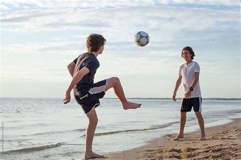 Teenage Boys Playing Soccer On The Beach Stocksy United