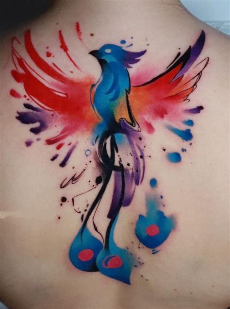 The Back Of A Womans Shoulder With Colorful Watercolor Tattoos On Her Body