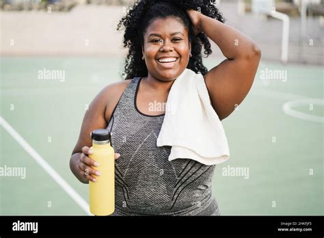 Curvy African Woman Smiling At Camera While Doing Running Routine In Park City Focus On Face