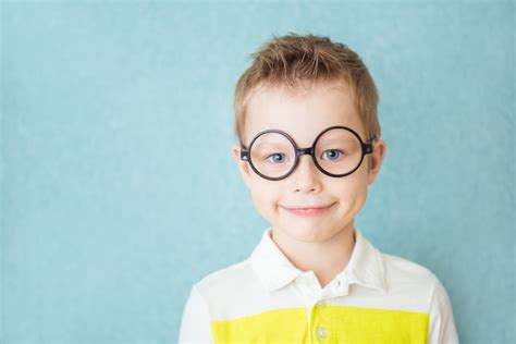 Retrato De Un Niño Sonriente Con Gafas En Azul Foto Premium