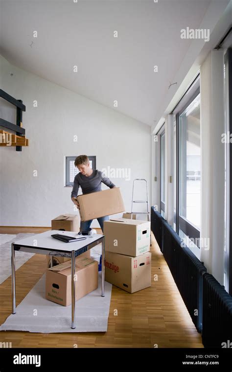 Man Stacking Cardboard Boxes In House Stock Photo Alamy