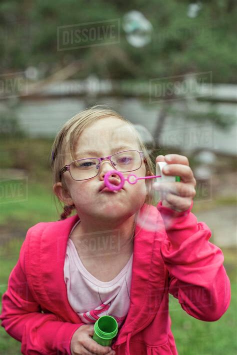 Girl Blowing Bubbles In Lawn Stock Photo Dissolve