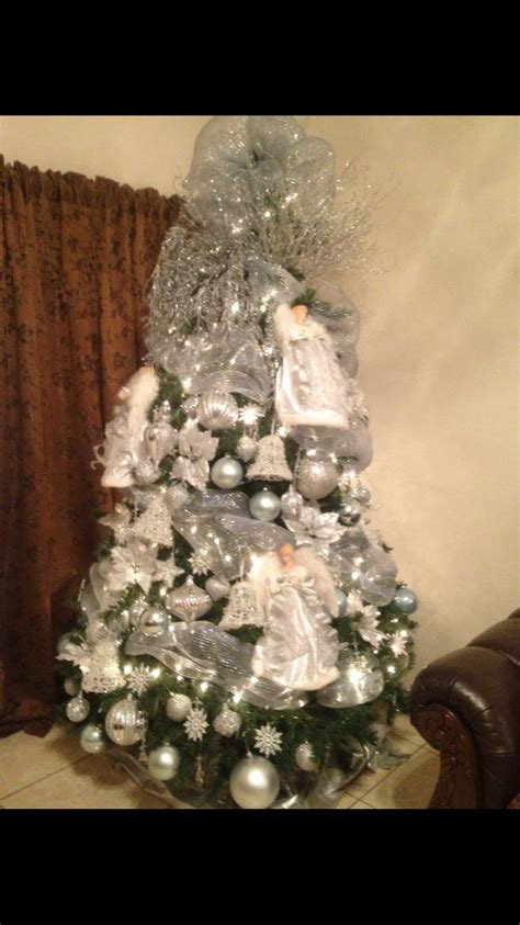 A White Christmas Tree Decorated With Silver Ornaments