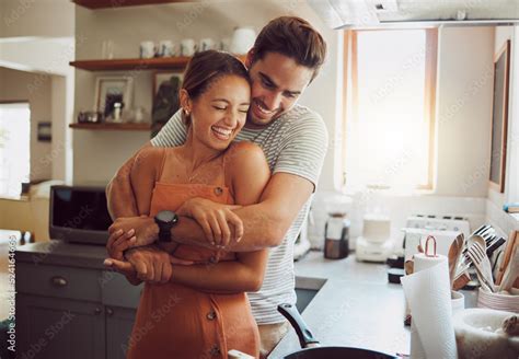 Love Romance And Fun Couple Hugging Cooking In A Kitchen And Sharing
