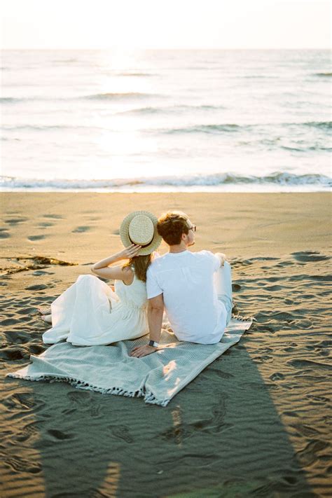 Девушка с парнем сидят на пледе на пляже Ада Бояна в Черногории Фотосессия на пленочный