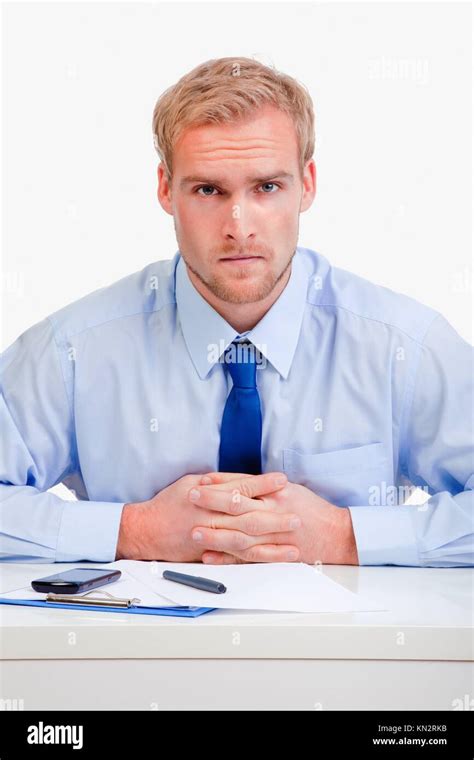 Serious Boss Sitting Behind Desk At Office Looking At Camera Stock