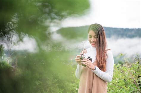 Young Asian Woman Taking Photo With Retro Film Camera Among The Nature