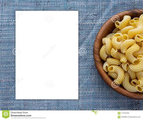 Rigati Macaroni In A Wooden Bowl On A Blue Knitted Background White