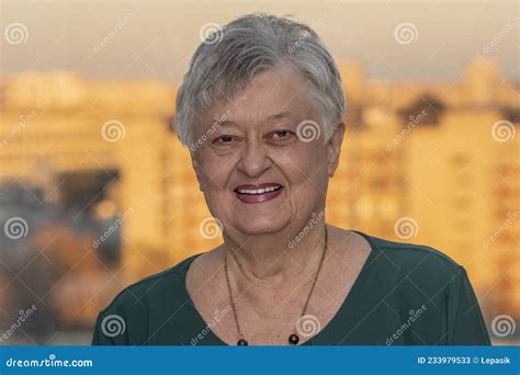 portrait of a smiling elderly woman over 70 years old with gray hair against the backdrop of