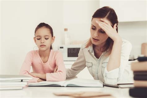 Mom Helps My Daughter Do Her Homework In The Kitchen Stock Image